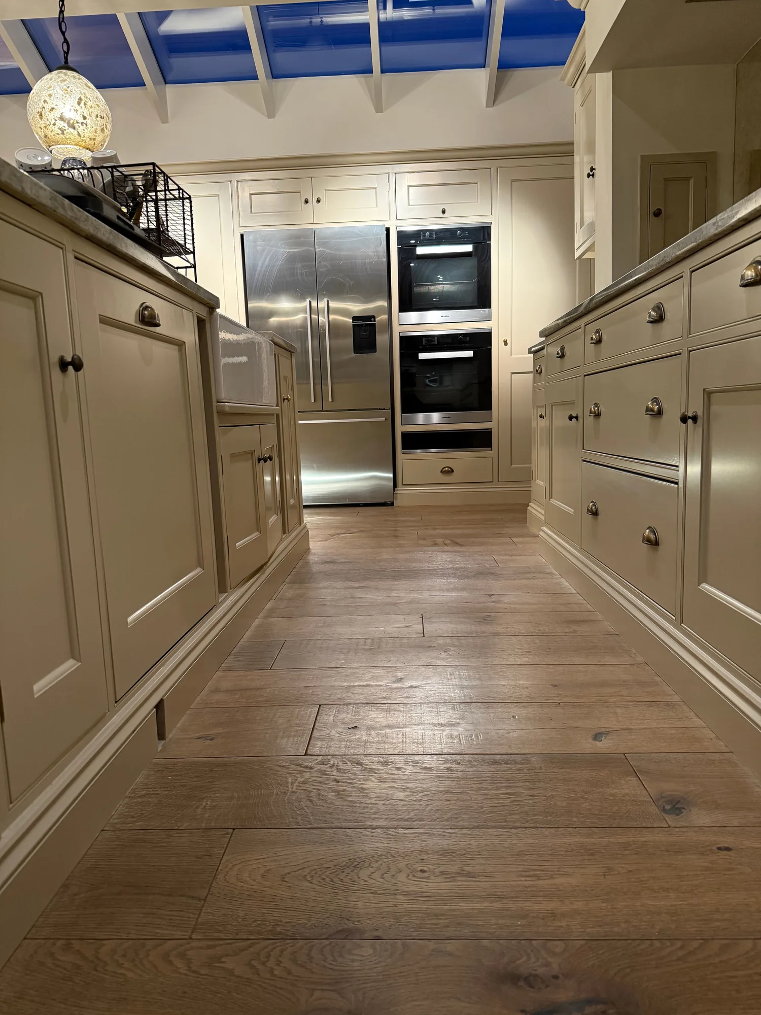 Cream in frame kitchen with double ovens and an oak floor