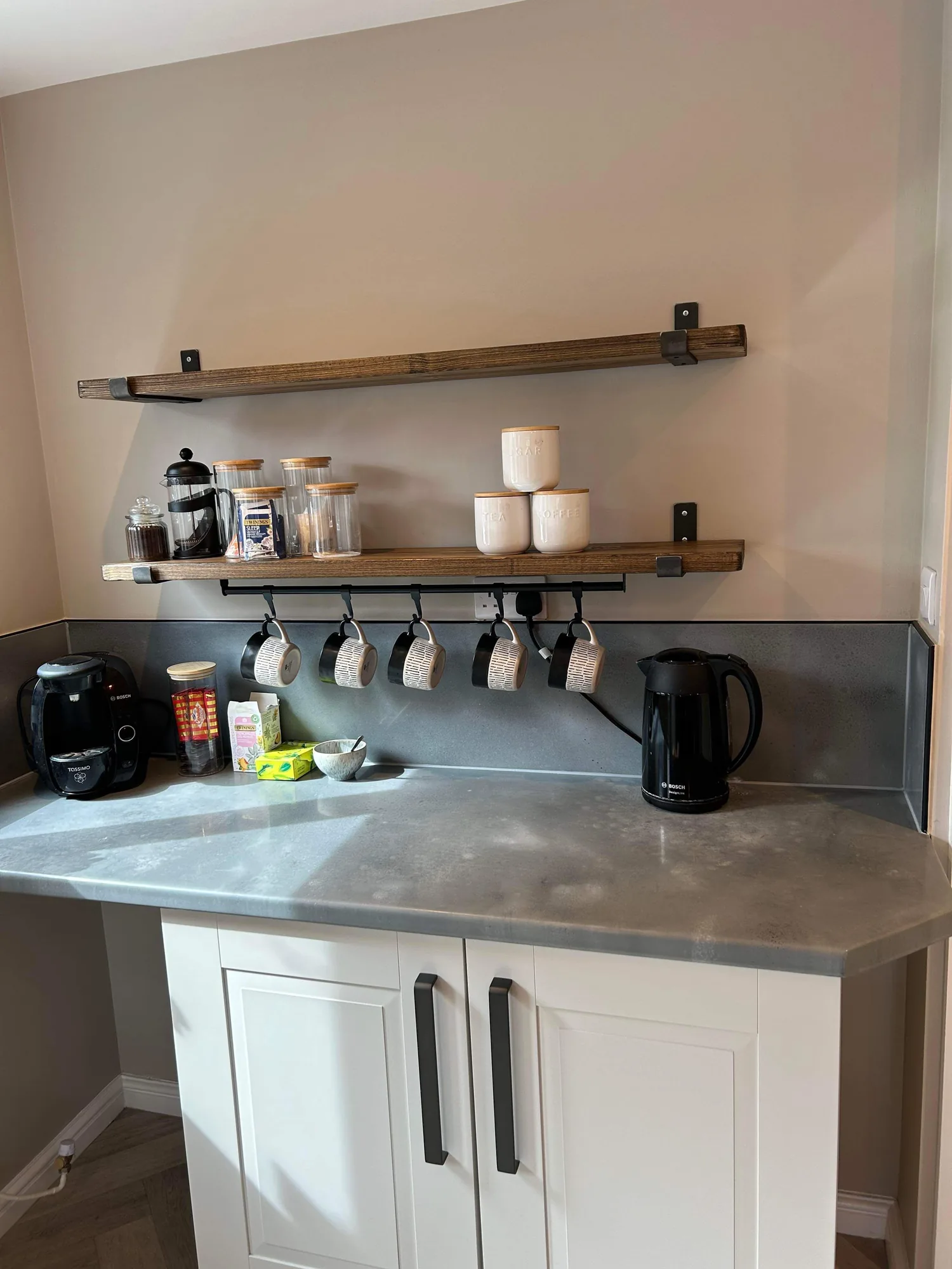 Grey worktop with an open shelf and splashback
