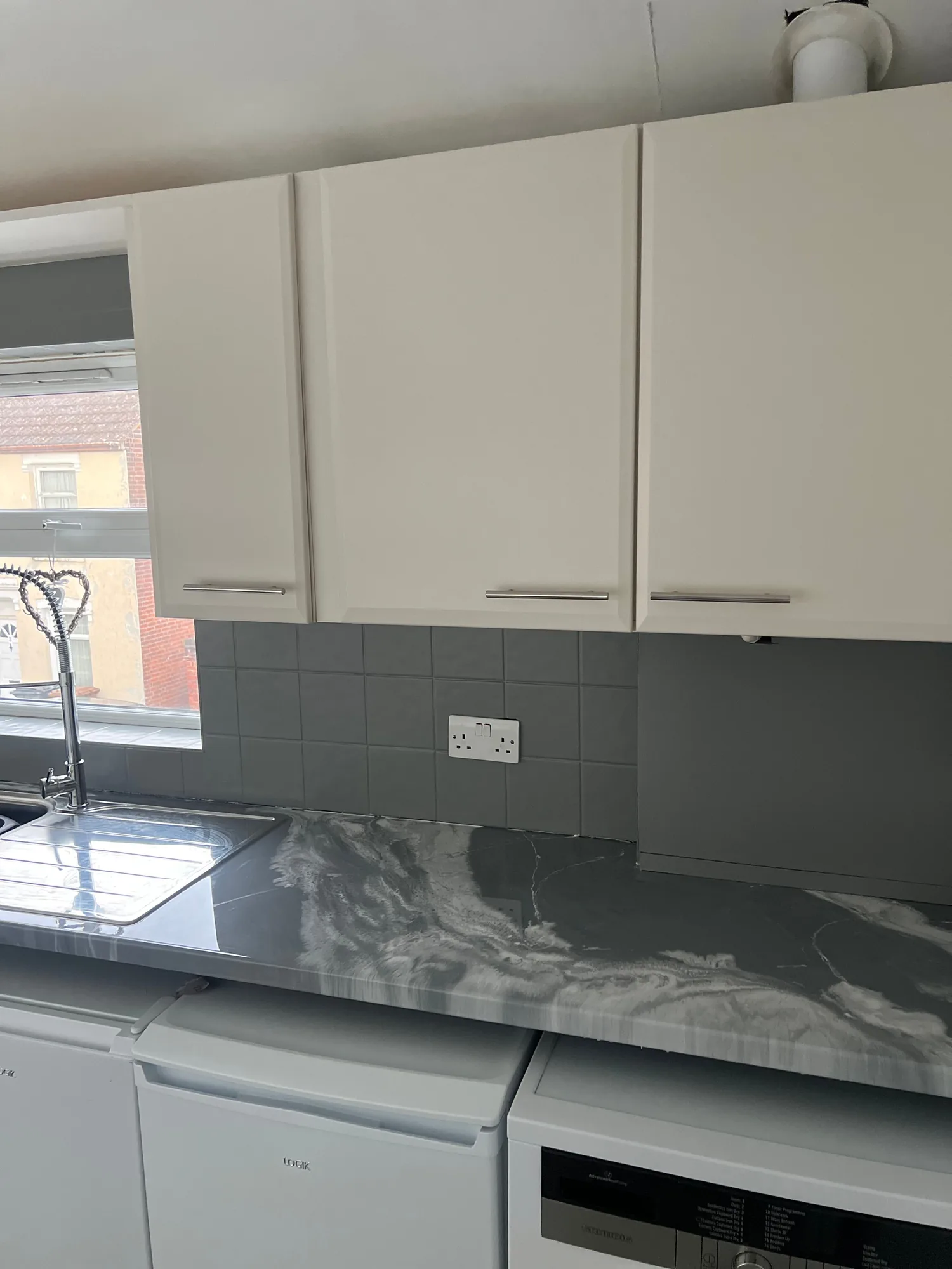 Dark marble effect worktop with a glass splashback